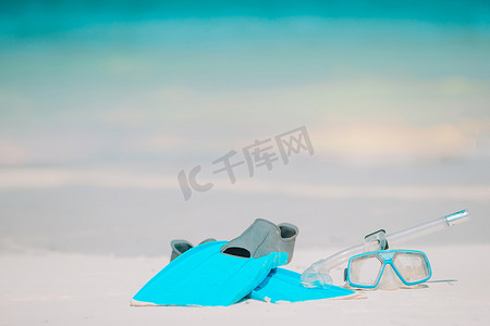 白色沙滩上的浮潜设备面罩、呼吸管和脚蹼