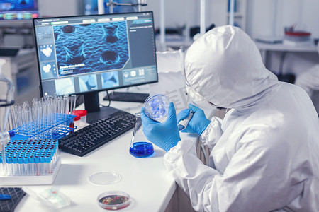化学实验室的科学家拿着带病毒样本的培养皿