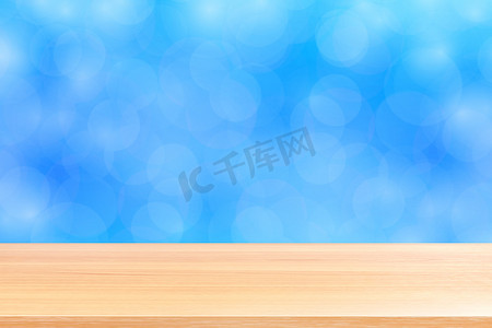 产品横幅广告摄影照片_模糊的散景柔和蓝色渐变背景上的空木桌地板，蓝色散景彩色浅色上的木板空，彩色散景灯渐变蓝色柔和，用于横幅广告产品