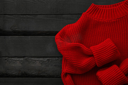 木质背景的红色针织毛衣，顶视图
