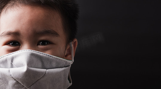 小孩眼睛摄影照片_戴着防护面罩的亚洲小孩带着恐惧