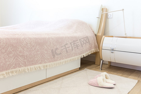 空卧室摄影照片_现代风格的卧室，地板上铺着粉色舒适的软拖鞋