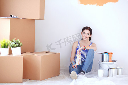 坐在木地板上的女人从色板中为新家选择油漆颜色。