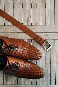 棕色男鞋，木质背景带鞋带，棕色