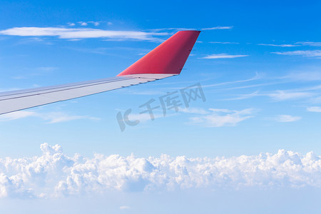 航空机翼摄影照片_飞行在云层之上的飞机的机翼