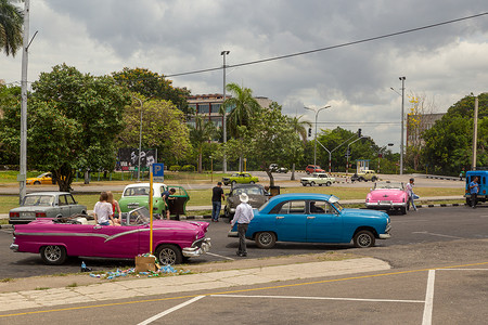 绿色经典摄影照片_古巴哈瓦那 — CIRCA 2017：一群美国绿色经典出租车在古巴韦达多革命广场等待游客