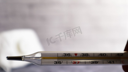 体温计摄影照片_冠状病毒医用面罩和测量温度的温度计。