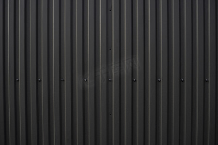 灰色波纹背景摄影照片_用作仓库或工厂外墙的黑色波纹铁皮。