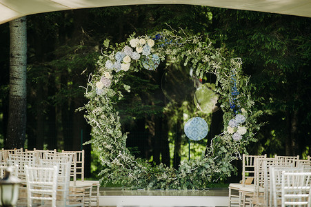 婚礼在绿色草坪的街道上举行。仪式用鲜花拱门装饰