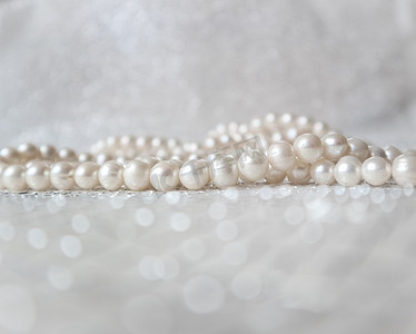 在闪闪发光的背景的自然白色珍珠小珠