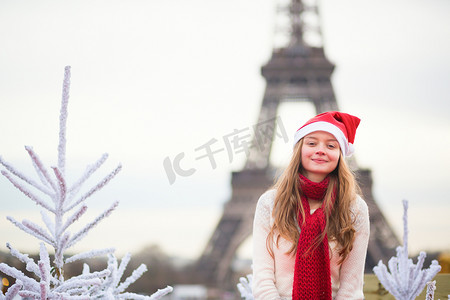 埃菲尔铁塔附近戴着圣诞老人帽子的女孩