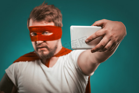超级英雄博主在手机上为他的博客或社交网络上的故事制作自拍照片或视频。