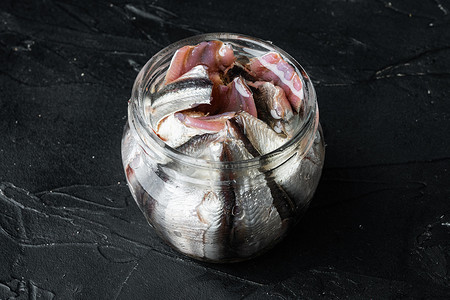 罐装凤尾鱼，在玻璃罐中，黑色背景，带有复制空间和文本空间