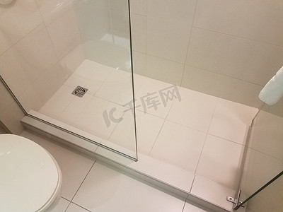 卫生间门摄影照片_带白色瓷砖和玻璃门的淋浴间和卫生间