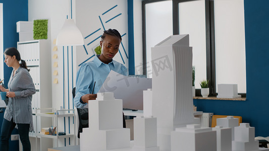 女建筑商分析蓝图计划设计建筑工地布局和建筑模型