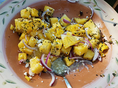 勺子黄色摄影照片_黄色西瓜，配洋葱、香草和奶酪，放在碗里，用勺子