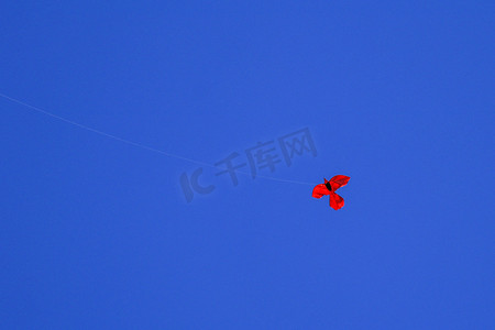天空深蓝摄影照片_在深蓝天空背景的风筝。