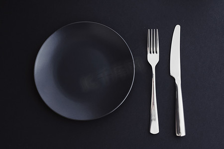 黑色背景中的空盘子和银器，高级餐桌