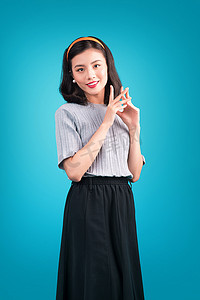 双旦狂欢海报摄影照片_微笑可爱的亚洲女人穿着蓝色的海报风格连衣裙。
