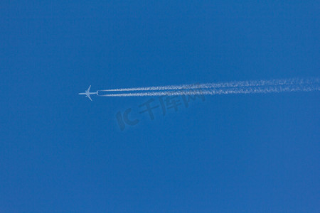 行动轨迹摄影照片_飞行的飞机在空中留下一条反转轨迹