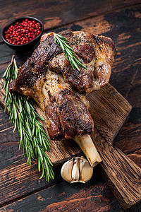 羊腿肉摄影照片_在木菜板上烤羊肉羊腿肉。