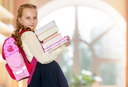 女学生肩上背着书包，手里拿着书