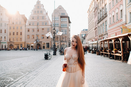 弗罗茨瓦夫老城，一位身着长发婚纱、手拿饮料瓶的新娘。