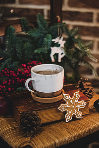 热巧克力摄影照片_圣诞热巧克力，在一个旧陶瓷杯里放着迷你棉花糖，在木制背景上放着蜡烛