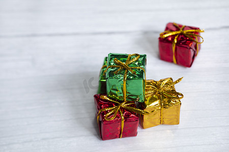 一堆彩色闪亮的礼盒，白色木质背景上有复制空间，现代复古圣诞设计，色彩缤纷的礼物，假日概念