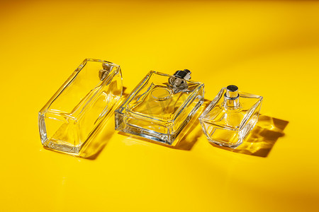 浅黄色背景上的香水玻璃瓶。
