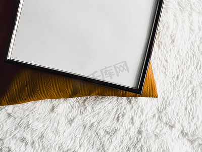 黑色金色海报摄影照片_带有空白复制空间的黑色薄木框作为海报照片打印模型、金色垫枕和蓬松的白色毯子、平躺背景和艺术产品