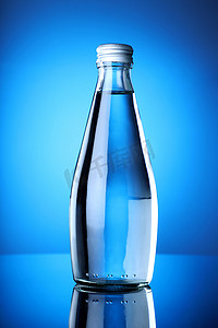 矿泉水瓶摄影照片_干净纯净的蓝色背景矿泉水瓶