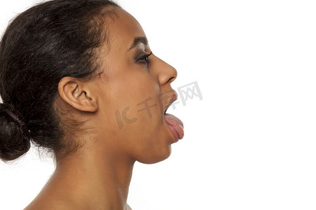 伸出舌头的年轻黑皮肤女人的侧影