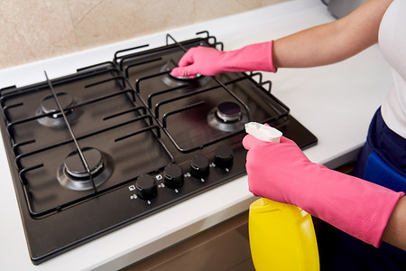 燃烧器摄影照片_用厨房用具、家居概念或卫生和清洁清洁燃气灶。