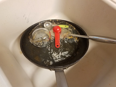 洗锅摄影照片_厨房水槽里有水的脏油腻煎锅