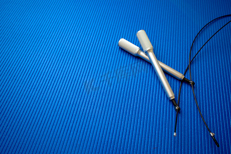 健身房蓝色垫子背景上的跳绳
