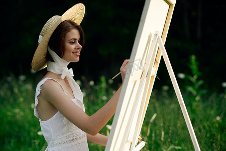 穿白裙的女人在自然画架上画一幅画