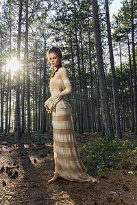 森林中针叶树附近穿着裙子的浪漫女人
