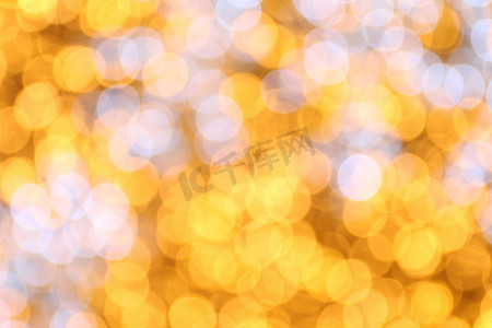 金黄色背景摄影照片_柔和的散景金黄色背景，散景金黄色五颜六色的圣诞快乐，新年快乐散景灯光在夜晚闪耀，散景闪光灯，金色奢华背景，闪闪发光的壁纸