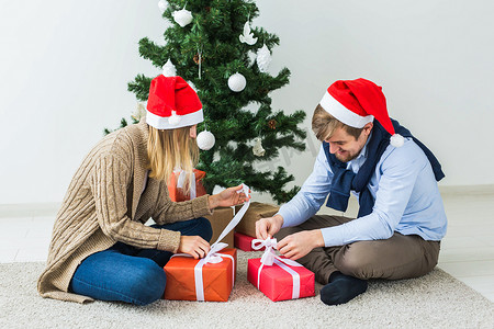 幕布开场摄影照片_假期、关系和节日概念 — 情侣在圣诞树旁一起开场