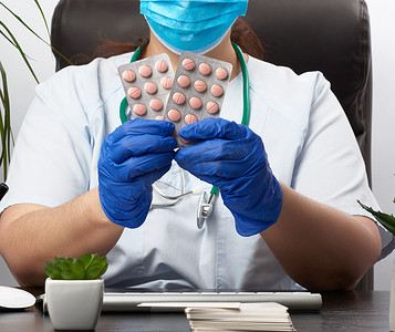 一堆药丸摄影照片_戴着蓝色无菌手套的女手拿着一堆药丸