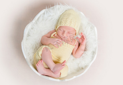 戴着帽子和睡在贝壳上的内裤的甜美新生婴儿