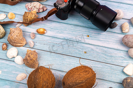 蓝色木质背景中的相机、椰子和贝壳 海洋主题