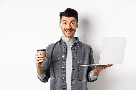 快乐的精力充沛的人喝着咖啡，在笔记本电脑上工作，从饮料中获得能量，站在白色背景上
