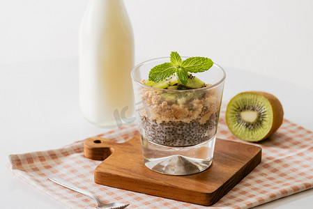 蓝莓酸奶摄影照片_健康早餐包括酸奶、坚果、猕猴桃和奇亚籽。