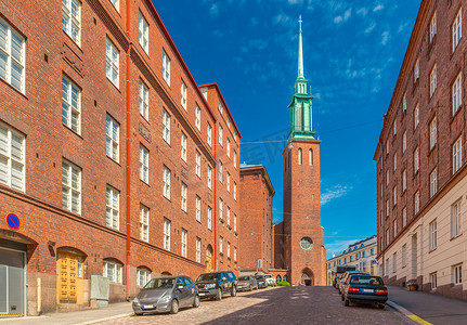 芬兰新哥特式风格的赫尔辛基街道与传统红砖建筑和教堂 (Kristuskyrkan) 的景色