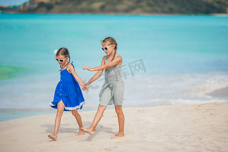 海滩小孩子摄影照片_快乐的小孩子在热带海滩一起玩耍，玩得很开心