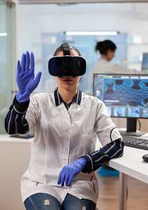 虚拟现实现实摄影照片_使用 vr 护目镜体验虚拟现实的实验室医生