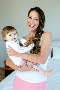 微笑的黑发女人抱着一个可爱的婴儿
