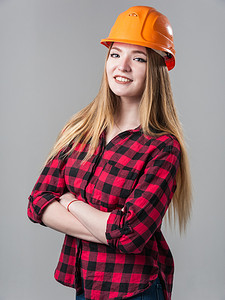 一个年轻漂亮的女人的画像，金发在中性灰色背景上的橙色头盔。